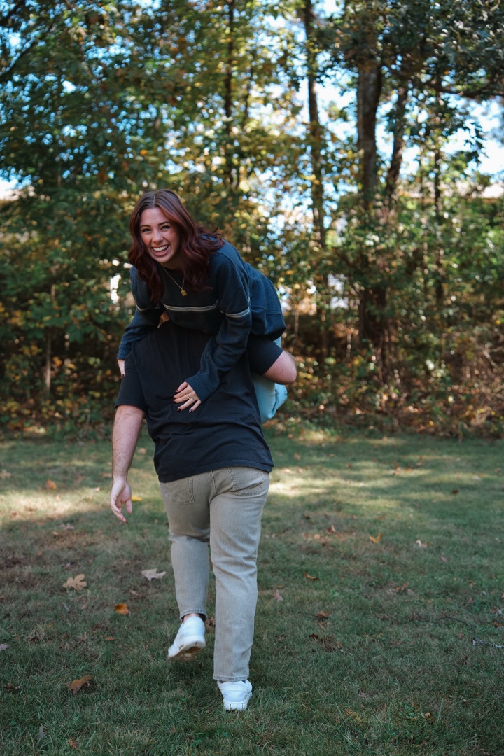 Couple piggyback laughing outdoors
