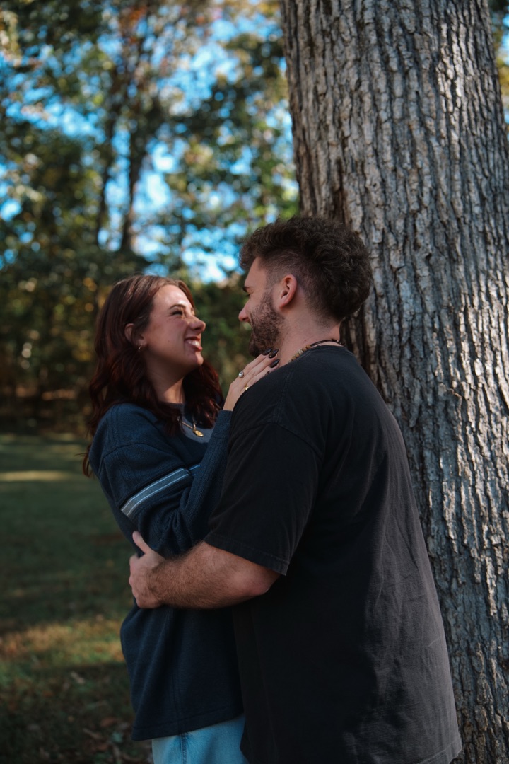 Couple embracing against a tree