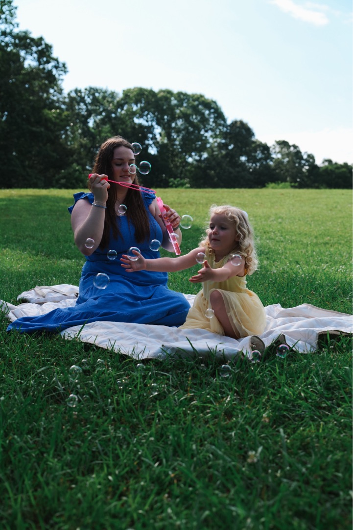 Mother and daughter blowing bubbles in the park