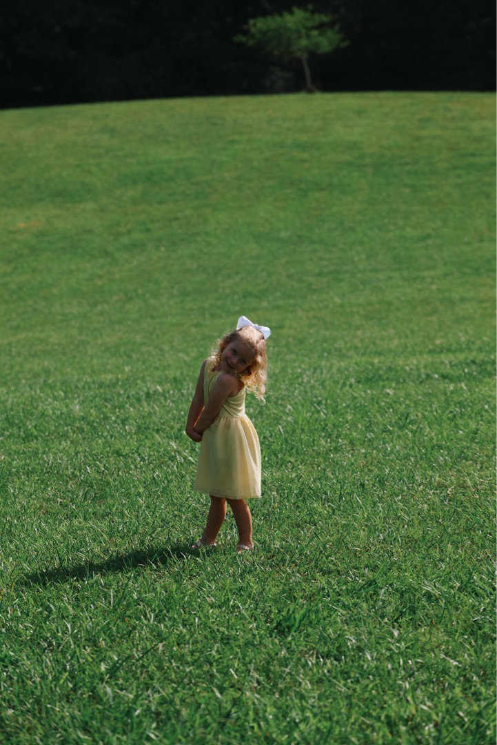 Little girl in yellow dress in a field