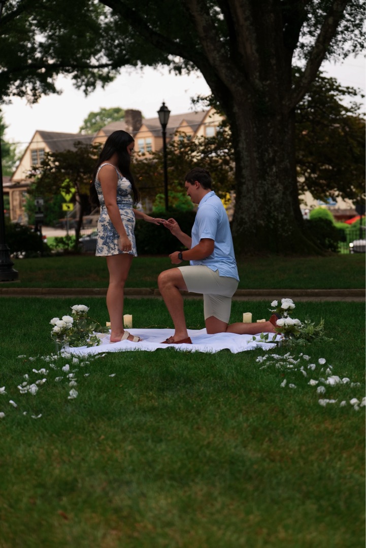 Proposal on one knee with candles and roses