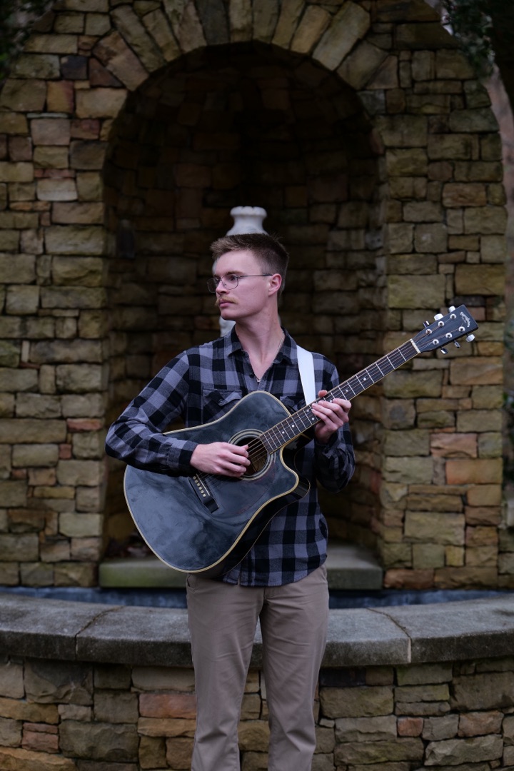 Senior portrait with guitar at stone fountain