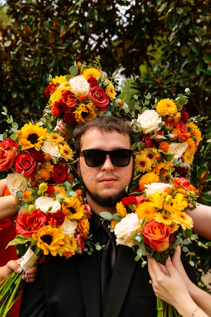 Groom surrounded by colorful bouquets